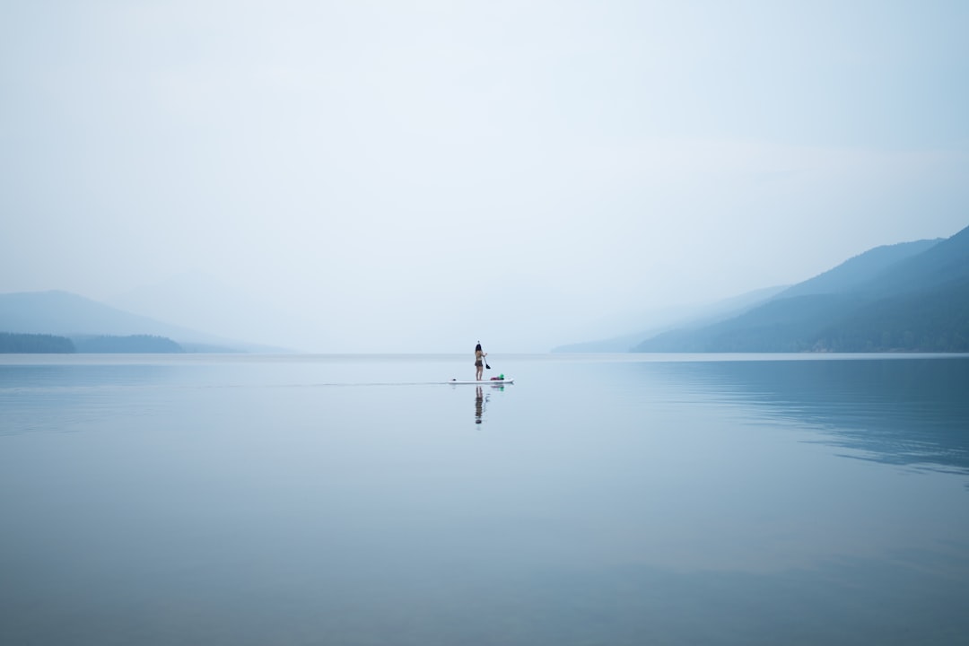 faith anchored — photo of person on calm body of water
