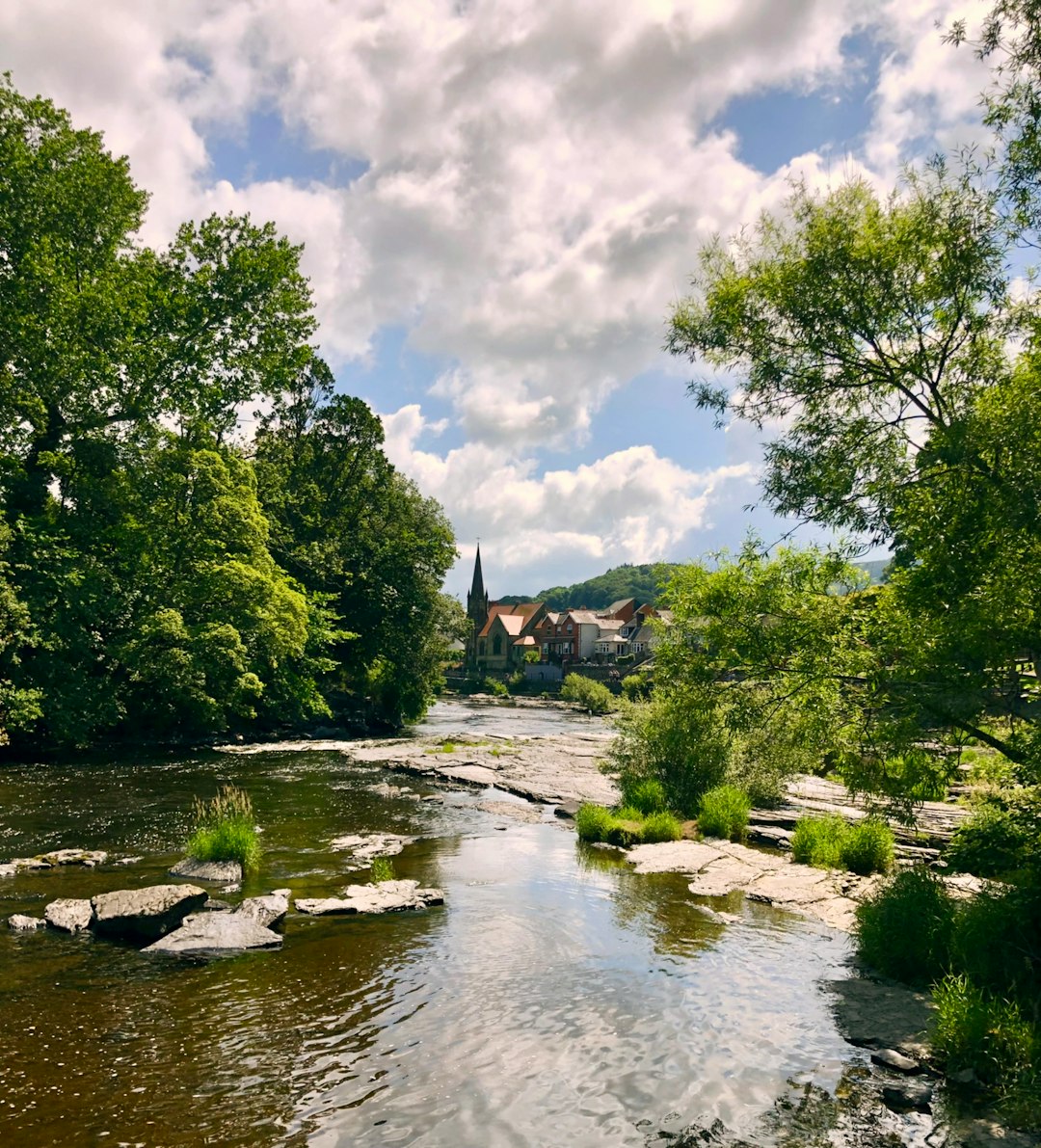 prison communication — River flows to the village under a cloudy sky.
